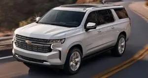 mrchauffeurcolorado | Sleek white 2025 Chevrolet Suburban driving on a scenic road, highlighting its modern design and spacious luxury