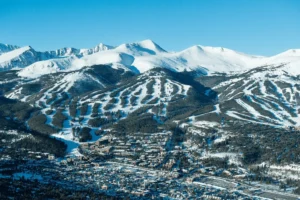 Aerial view of Breckenridge Ski Resort with snow-covered slopes and mountain town — top Colorado destination with Breckenridge airport shuttle and private transportation services