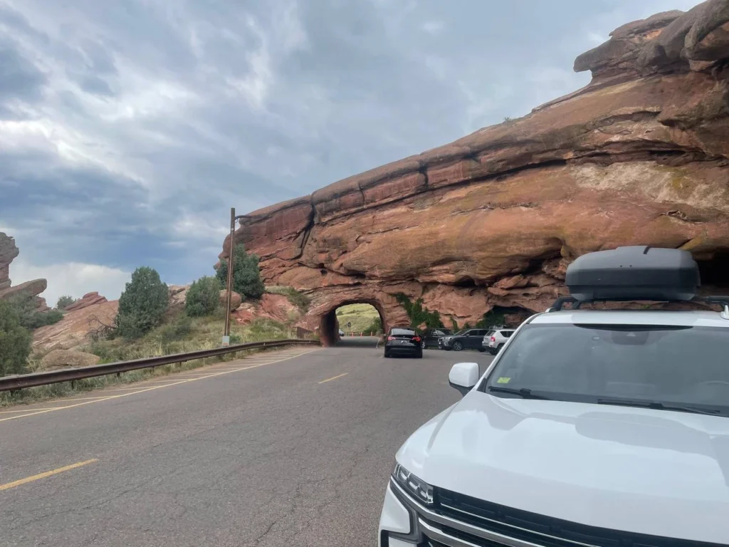 Private shuttle parking at Red Rocks Park Colorado near natural rock tunnel and scenic sandstone cliffs