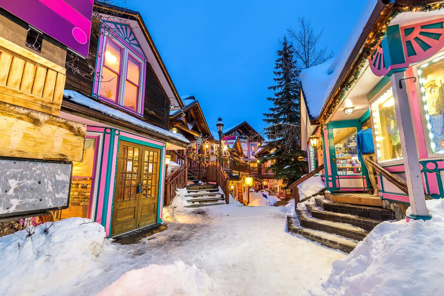 Winter evening in colorful Breckenridge shops covered with snow - private car service from Denver