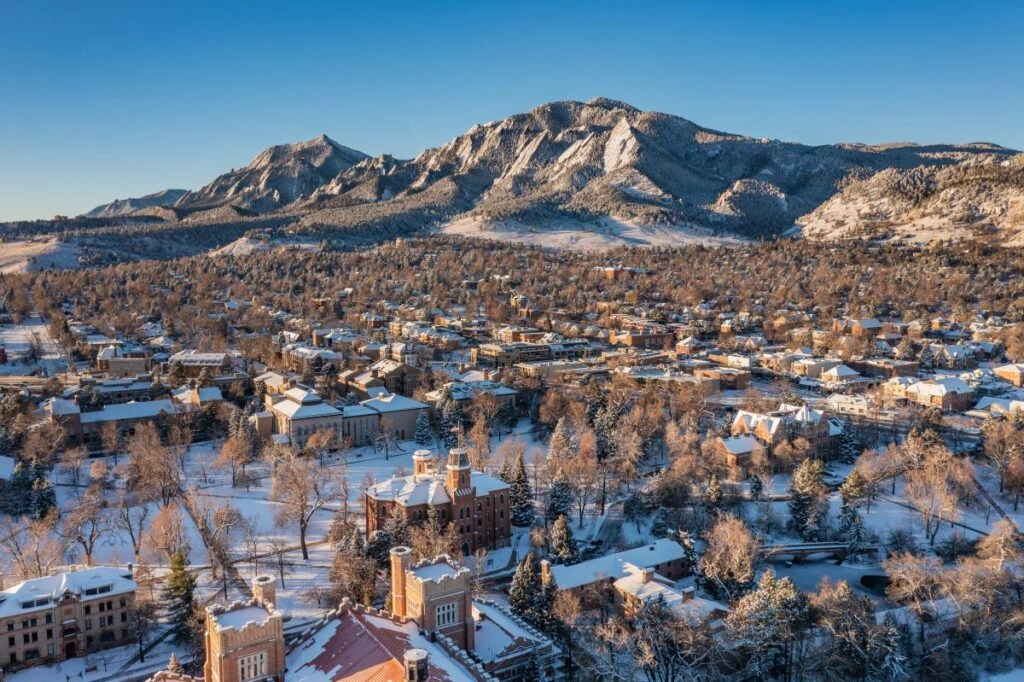Boulder Colorado Flatirons view in winter with snow covered city, private car service Boulder to Denver airport