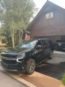 Luxury black SUV Suburban private shuttle service in Colorado mountain town driveway