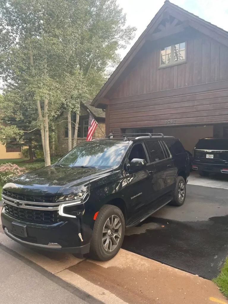 Luxury black SUV Suburban private shuttle service in Colorado mountain town driveway
