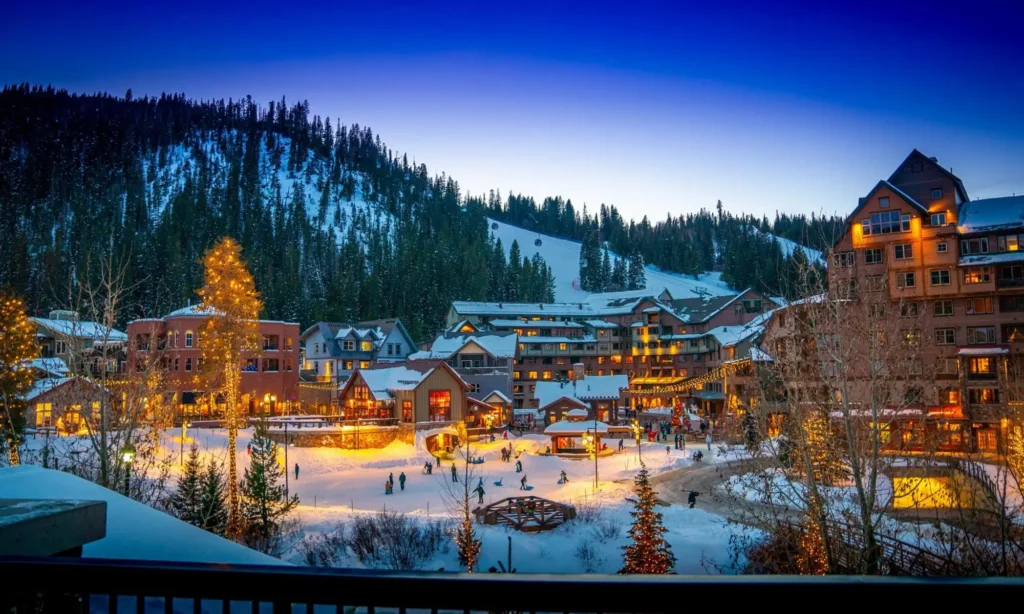 Winter evening at a Colorado ski resort - Winter Park with snow-covered buildings, holiday lights, and guests enjoying outdoor activities, ideal destination for shuttle service transportation