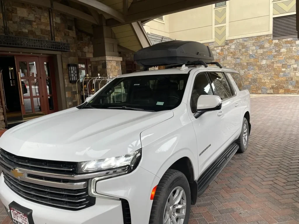 White luxury SUV at Four Seasons Resort Vail. Private car service from Denver to Vail by Mr. Chauffeur Colorado.