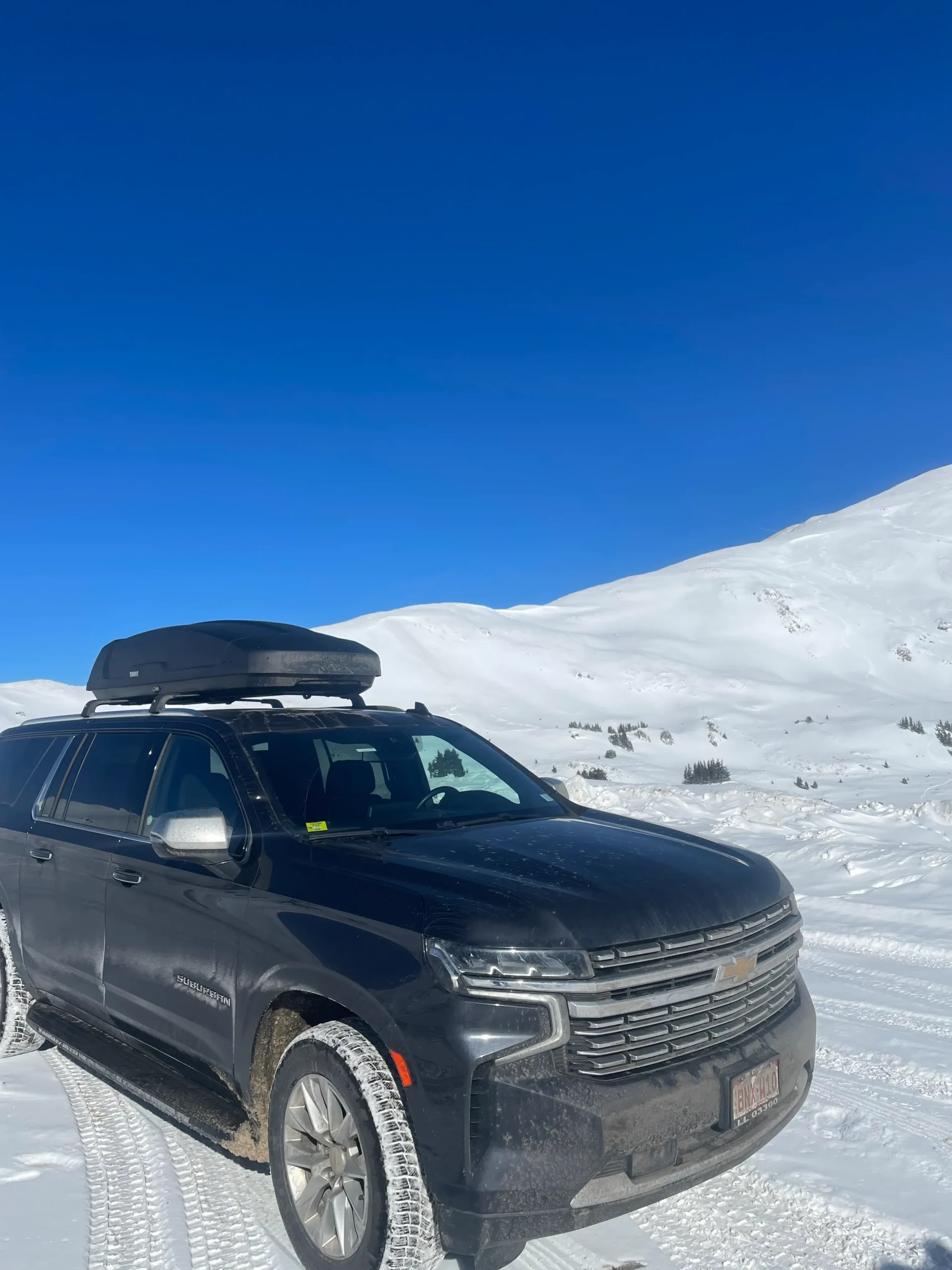 Mr. Chauffeur Colorado's black luxury SUV (Chevy Suburban) with ski storage cargo box, offering reliable private transportation for families from Denver to Colorado ski resorts.