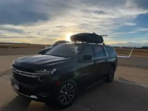 Black luxury SUV on tarmac at Centennial Airport. Private shuttle service for private aviation. Mr. Chauffeur Colorado.