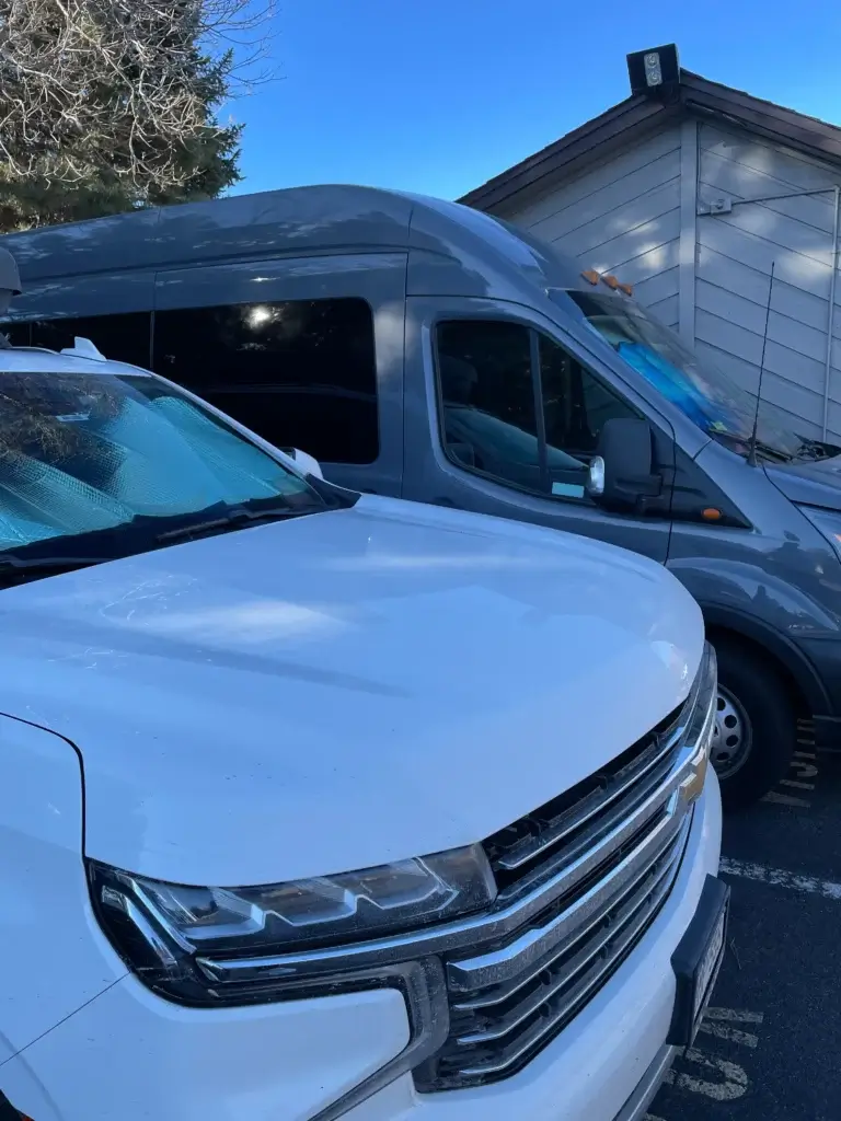 White Chevrolet Suburban and grey sprinter van. Private airport fleet options by Mr. Chauffeur Colorado.