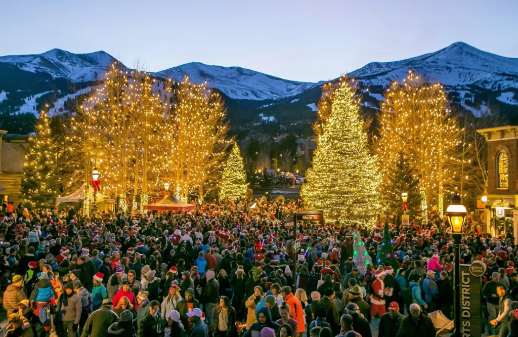 Holiday celebration and crowd on Main Street Breckenridge with Christmas lights. Private luxury shuttle to Breckenridge events by Mr. Chauffeur Colorado.