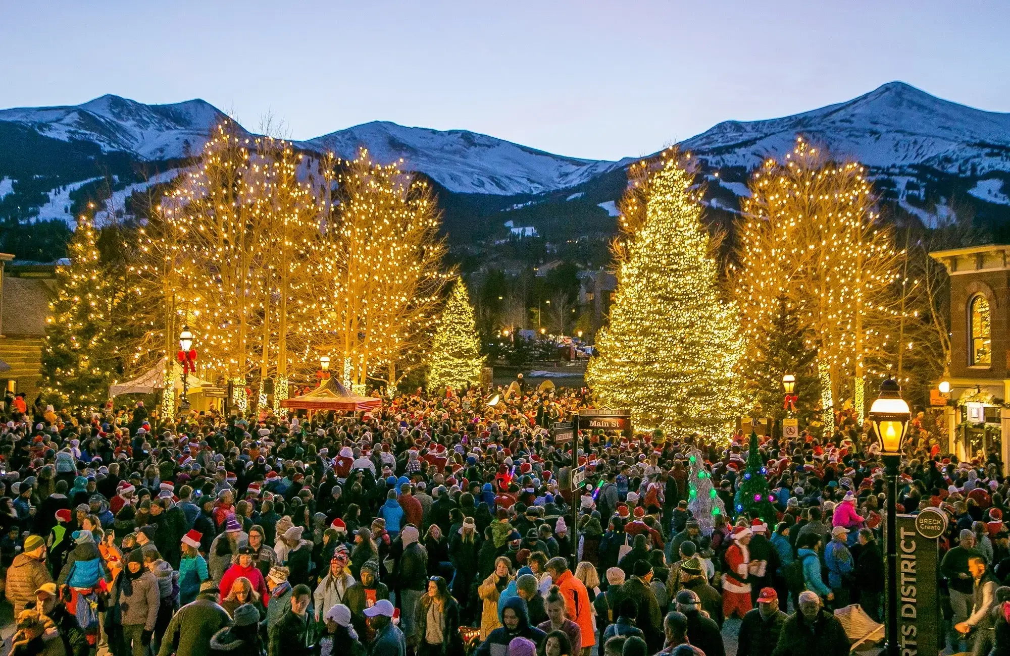 Holiday celebration and crowd on Main Street Breckenridge with Christmas lights. Private luxury shuttle to Breckenridge events by Mr. Chauffeur Colorado.