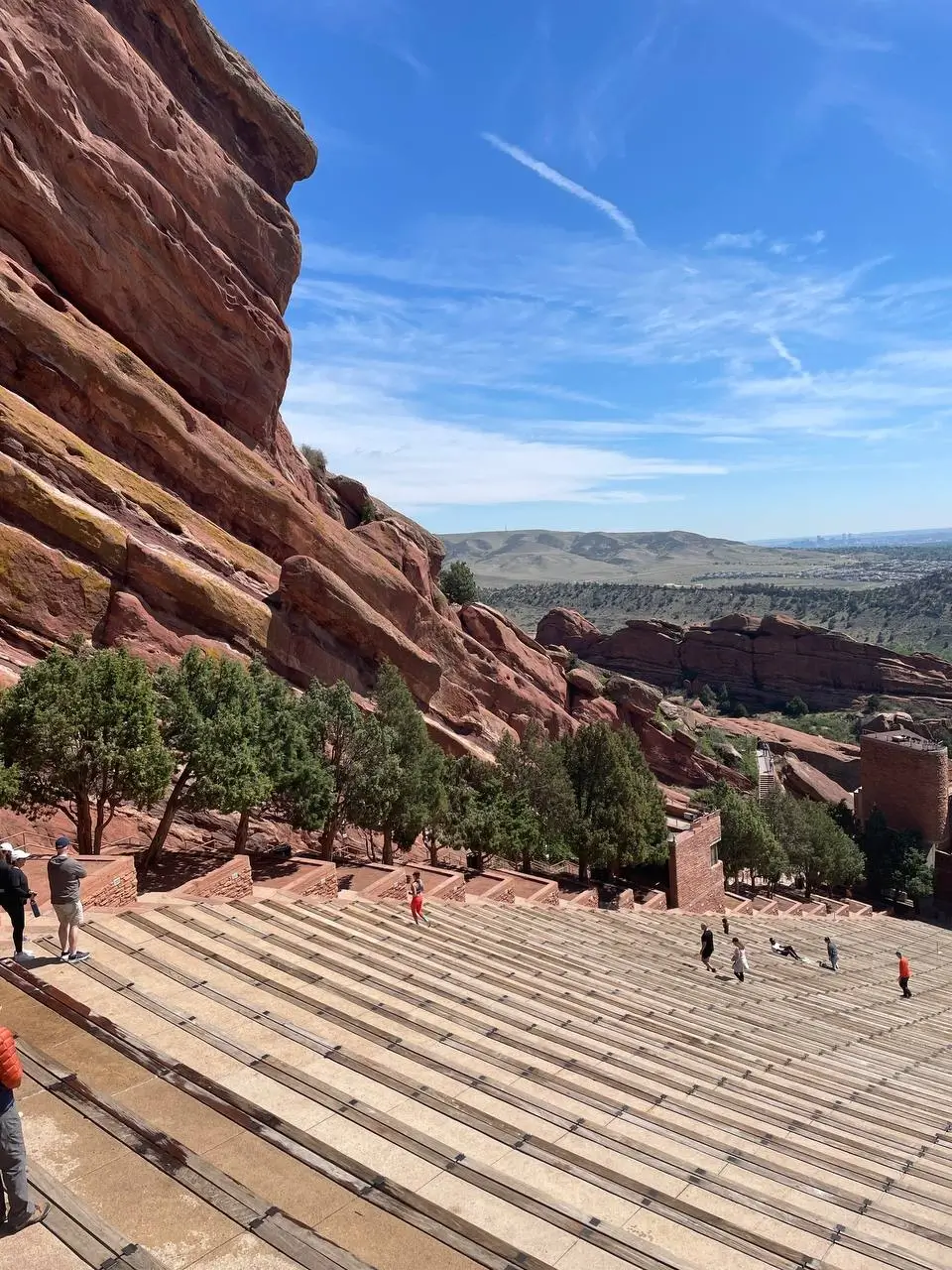 Red Rocks Amphitheatre in Colorado, with its iconic red rock formations towering over the tiered seating under a clear blue sky.