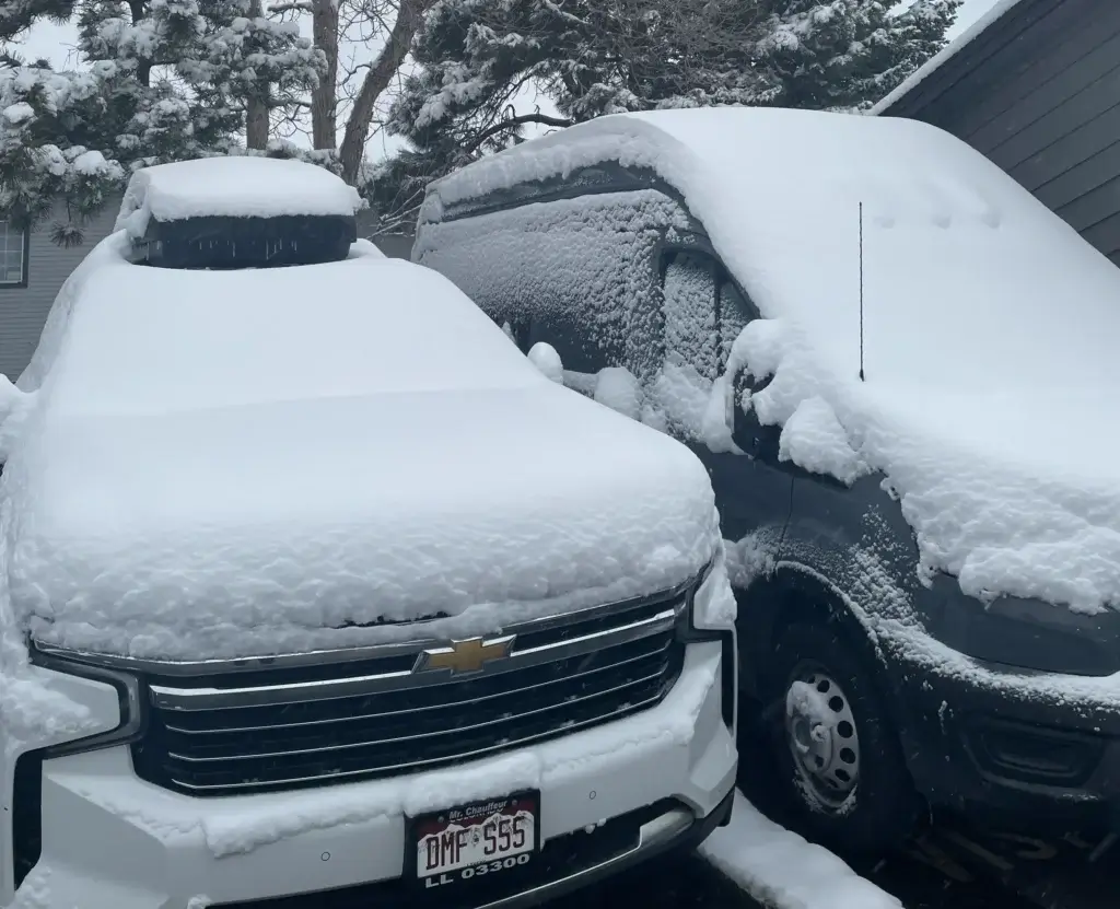 Snow-covered luxury SUV and Van. Reliable winter private car service for ski transfers by Mr. Chauffeur Colorado.